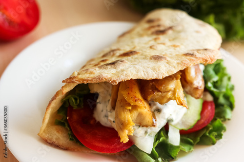 Pita with chicken, vegetables and sauce, delicious lunch, fast. 