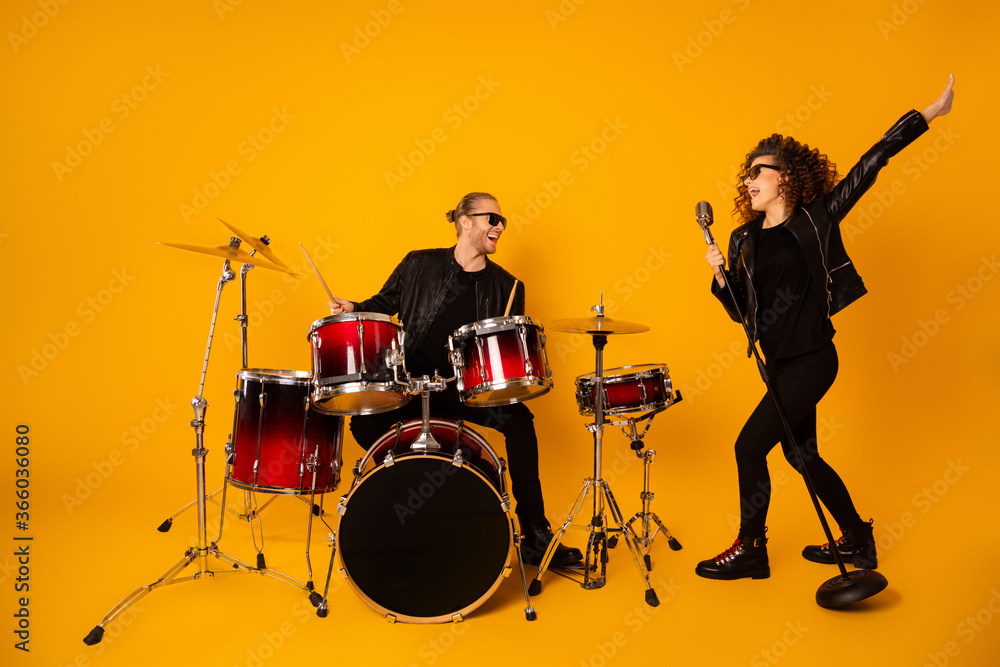 Φωτογραφία Full length photo of famous rock group guy plays instruments beat drum sticks at