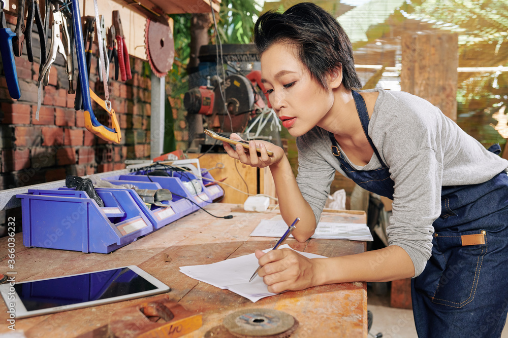 Εκτύπωση καμβά Carpenter recording voice message for customer and drawing scheme of furniture i