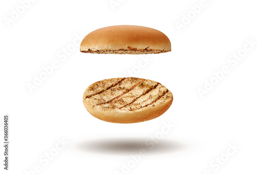 Flying and palatable, baked or grilled, two halves of burger bun isolated on white background. Concept of cooking and fast food. Close-up, copy space