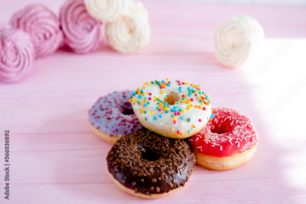 Variety of doughnuts and marshmallow on pink background. Junk food. Sweet food confectionery. Variety of doughnuts and marshmallow on pink background. Junk food. Sweet food confectionery.