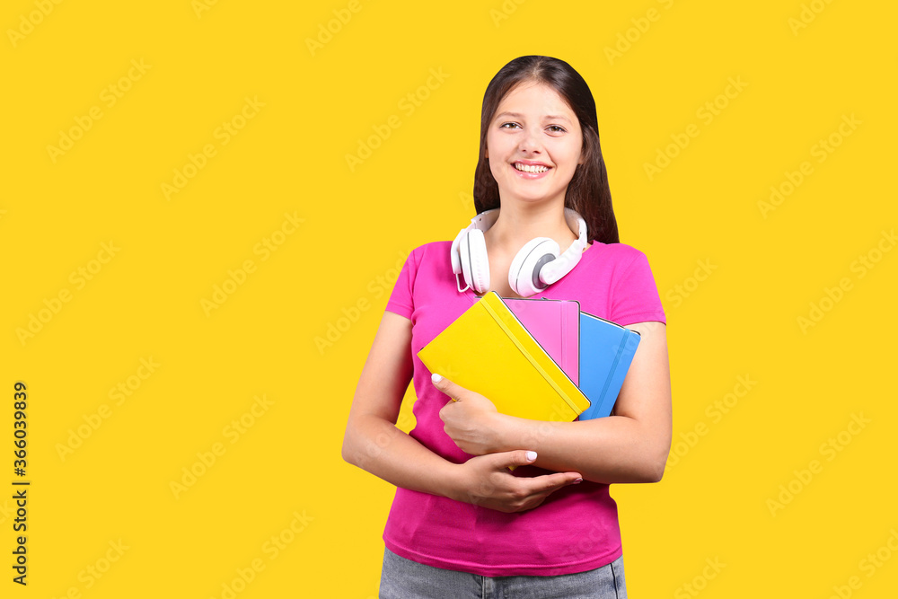 Young beautiful curvaceous woman with headphones posing over bright wall background with a lot of copy space for text. Portrait of attractive female with long brunette hair wearing pink t-shirt. Young beautiful curvaceous woman with headphones posing over bright wall background with a lot of copy space for text. Portrait of attractive female with long brunette hair wearing pink t-shirt.