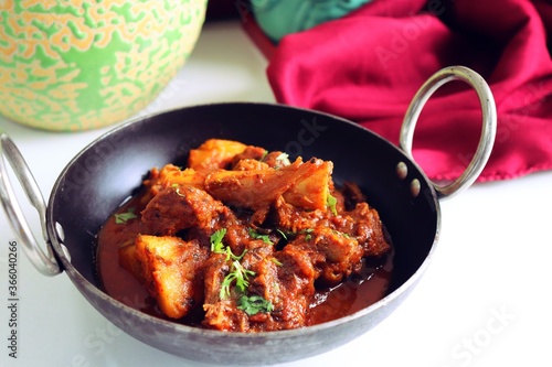 Mutton curry. Mutton Vindaloo gravy or mutton masala is a famous Spicy nonvegetarian dish of India. Its made out of Goat meat along with spices. Garnished with fresh coriander. copy space. photo