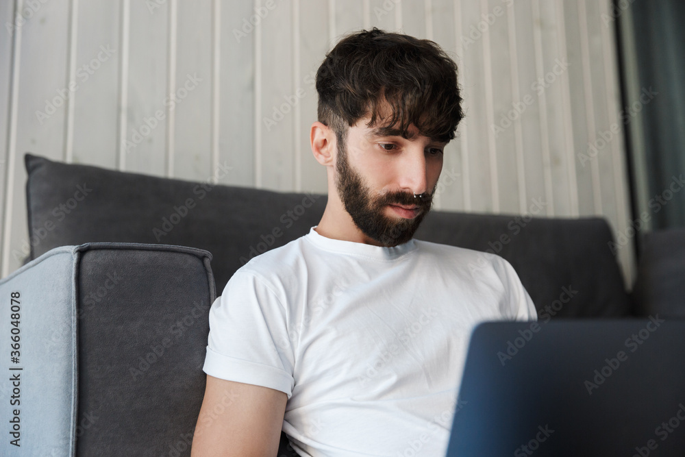 Handsome young bearded man using laptop computer Handsome young bearded man using laptop computer