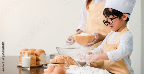 Mom teaching son for cooking food. Mother and kid daily lifestyle at home. Asian family together in the kitchen. photo