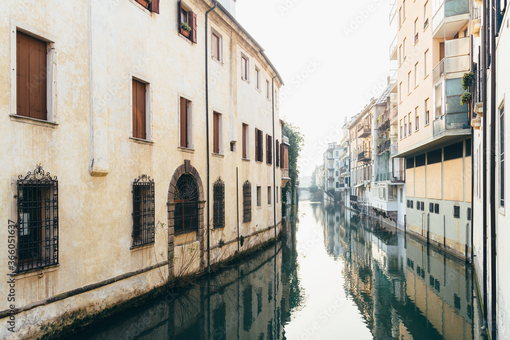 View of old houses and their reflection in a water canal Padua.