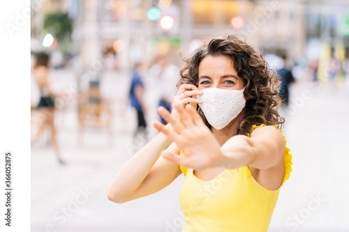 Brunette woman with a facial mask in the city