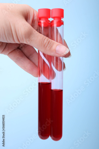 Test tubes with blood in a female hand