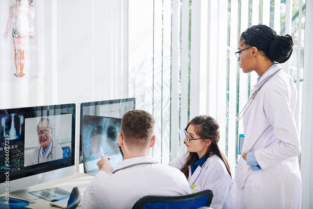 Group of young doctors discusing lungs x-ray of patient recovered from coronavirus Group of young doctors discusing lungs x-ray of patient recovered from coronavirus