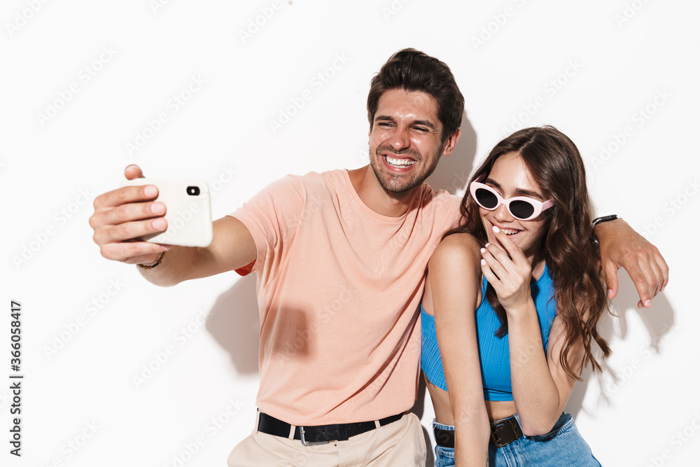 Image of attractive happy couple laughing while selfie on smartphone Image of attractive happy couple laughing while selfie on smartphone