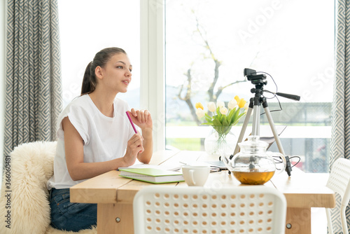 Influencer Young girl blogger talks about to your subscribers. Woman recording video blog tells be in social networks