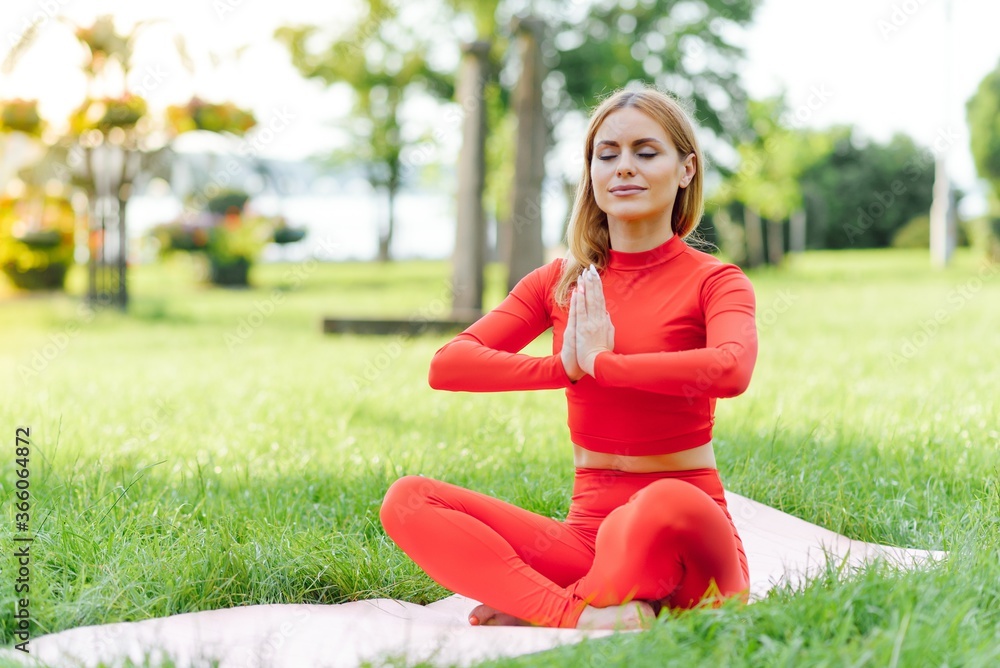 Pretty woman doing yoga exercises in the park Pretty woman doing yoga exercises in the park