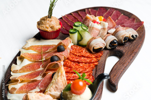 Assortment of cold meats, variety of processed cold meat products on a wooden board
