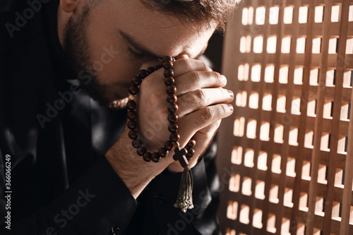 Young priest in confession ...