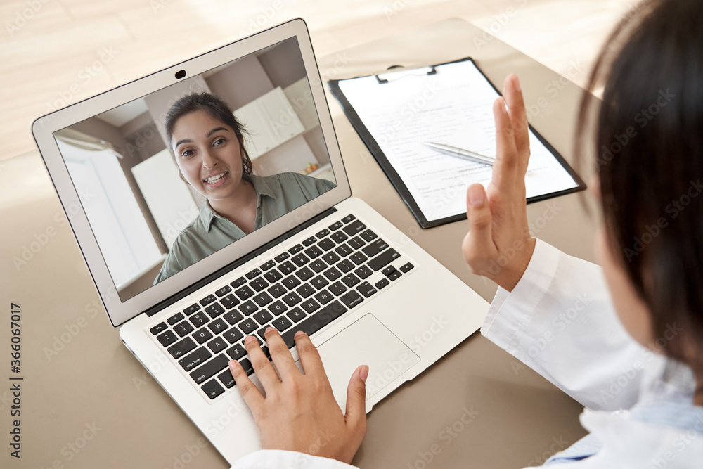 Female doctor gp consulting indian woman patient make online webcam video  call on laptop screen. Telemedicine conference remote computer virtual  visit in zoom meeting. Over shoulder videocall view. Stock Photo | Adobe