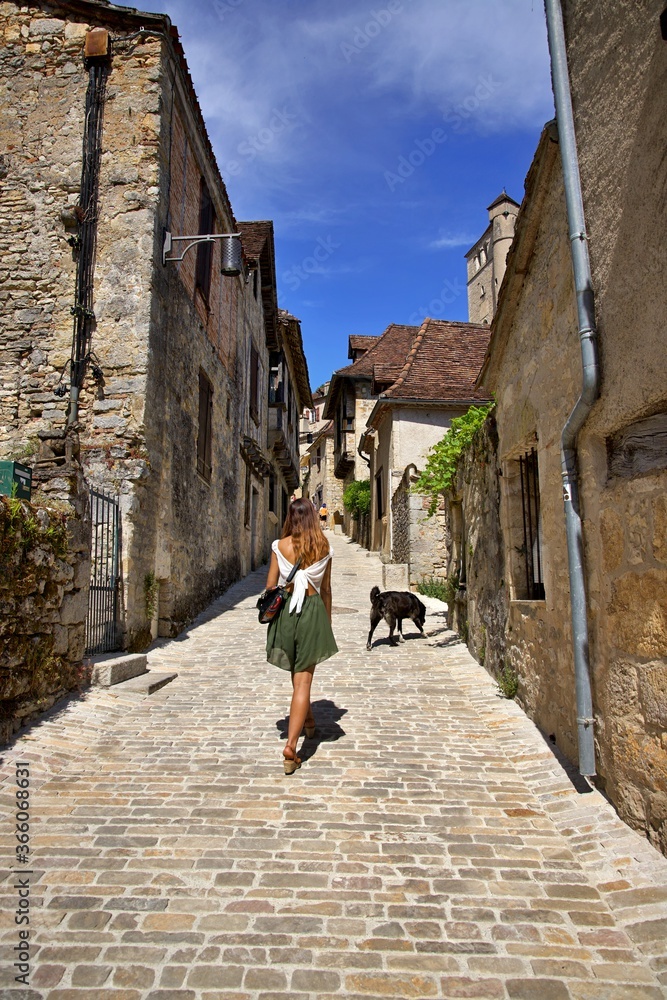 Tourisme France - jeune femme village ancien rue marche été - voyage découverte exploration