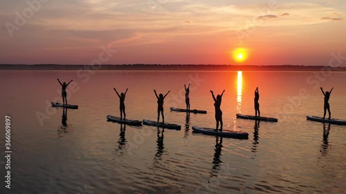 A group of girls doing yoga on the sup boards