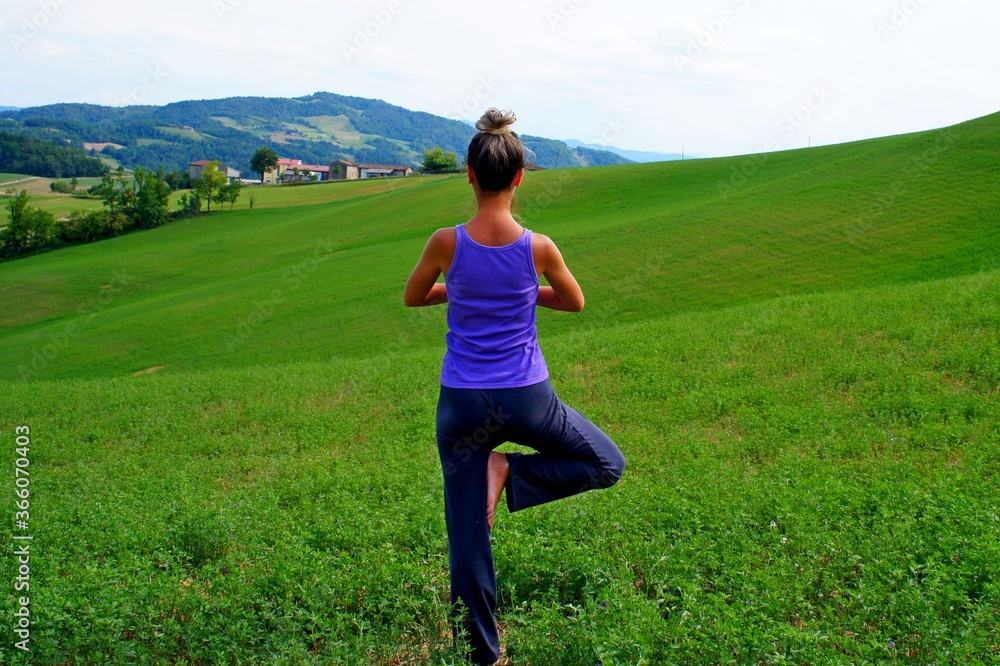 young woman doing yoga in the field young woman doing yoga in the field