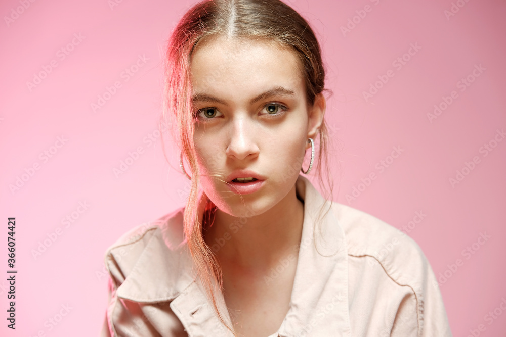 A girl in a pink denim shows different emotions and poses on a pink background.