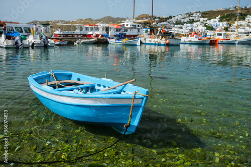 Greek fishing boat in clear sea water in port of Mykonos. Chora town  Mykonos  Greece