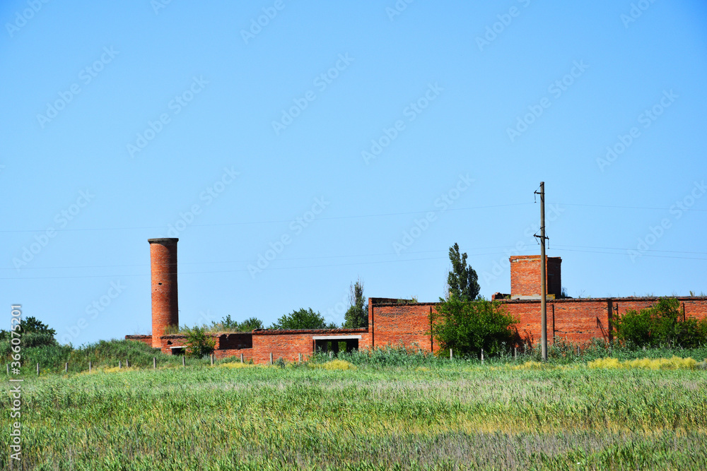 An old abandoned factory. Brick wall and destructible building of a once powerful factory.