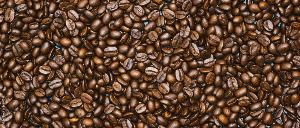 Obraz premium Top view of brown roasted coffee beans, can be use as background, copy space for text.
