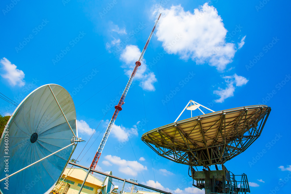 Signal Tower and Sky satellite dish are large and the clouds are white as a backdrop, high telecommunication signal, wireless access equipment, remote signaling, high steel antenna.
