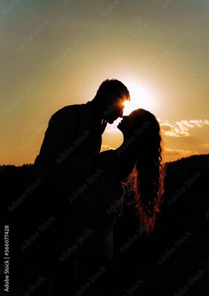 Wonderful silhouette of a couple in love at sunset.