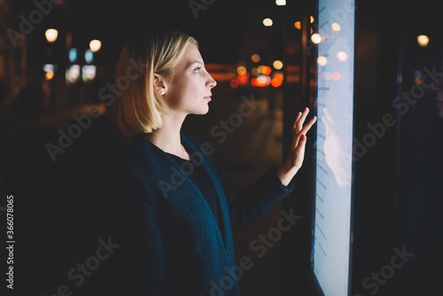 Quadro em tela Attractive young woman consults on modern big timetable outdoors, female caucasi