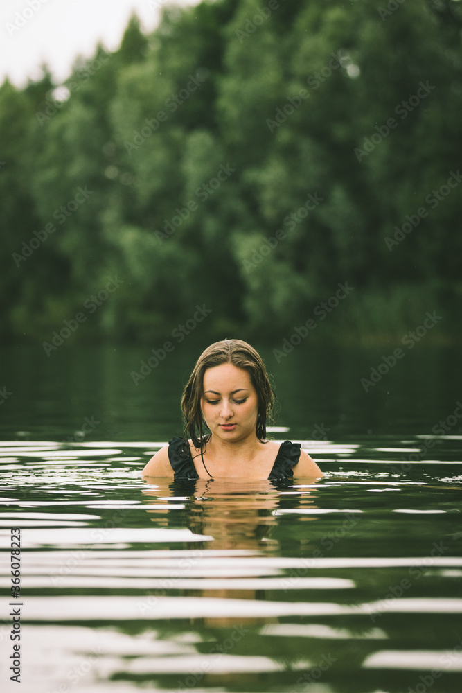 Fototapeta premium Junge Frau im Monokini genießt eine Abkühlung im Badesee