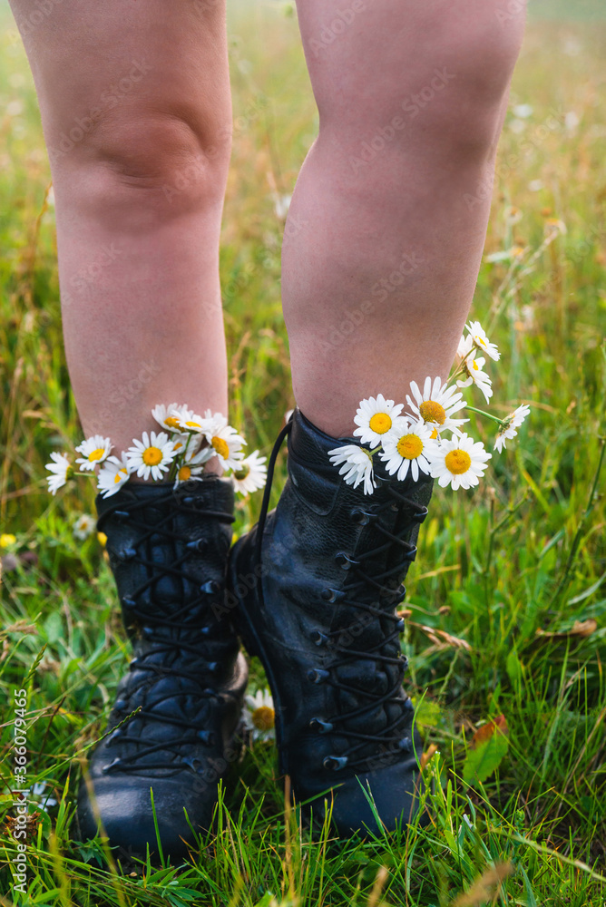 Girl tourist in boots with daisies