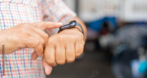 close up mature woman touch screen on digital smart watch to checking time or health checkup application at home for senior people and lifestyle concept © chinnarach