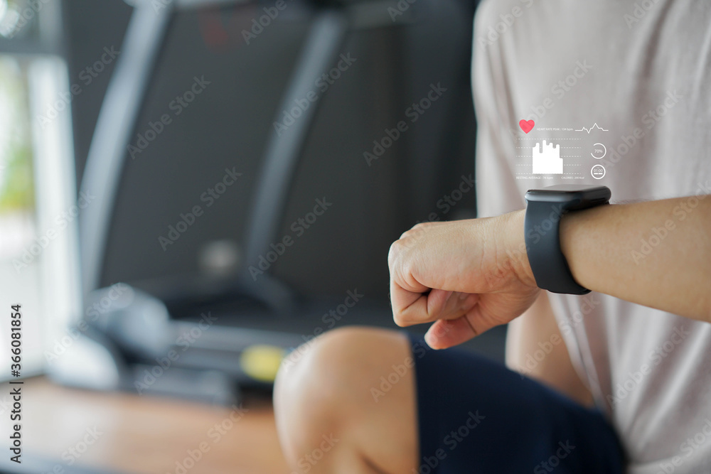 close up young man using smart watch to monitoring about healthcare tracker with virtual display to measure heart rate and calories while workout and rest for technology and futuristic life concept