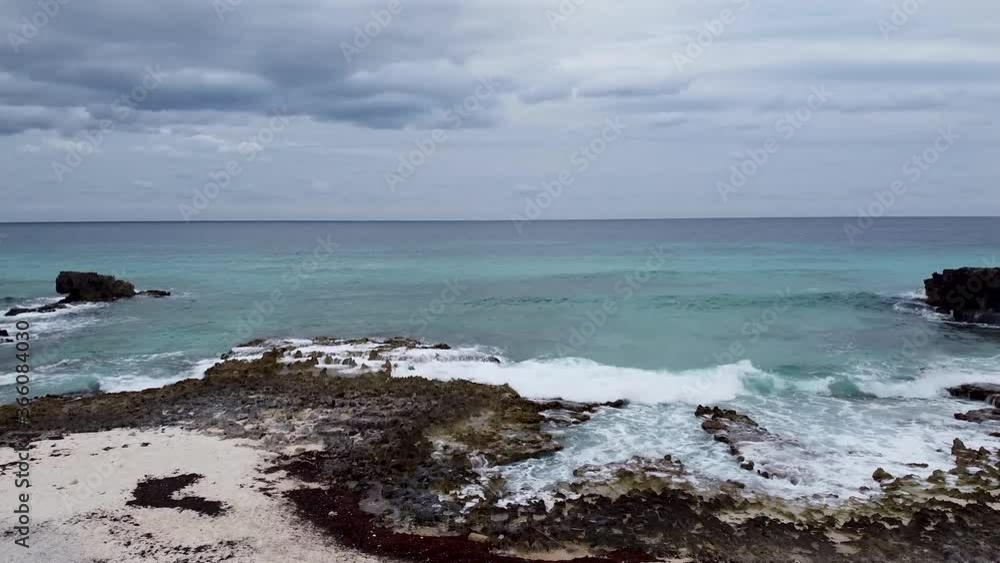 Aerial drone flying from a rocky and white sand beach towards a rough but clear Caribbean Sea in Cozumel, Mexico Aerial drone flying from a rocky and white sand beach towards a rough but clear Caribbean Sea in Cozumel, Mexico