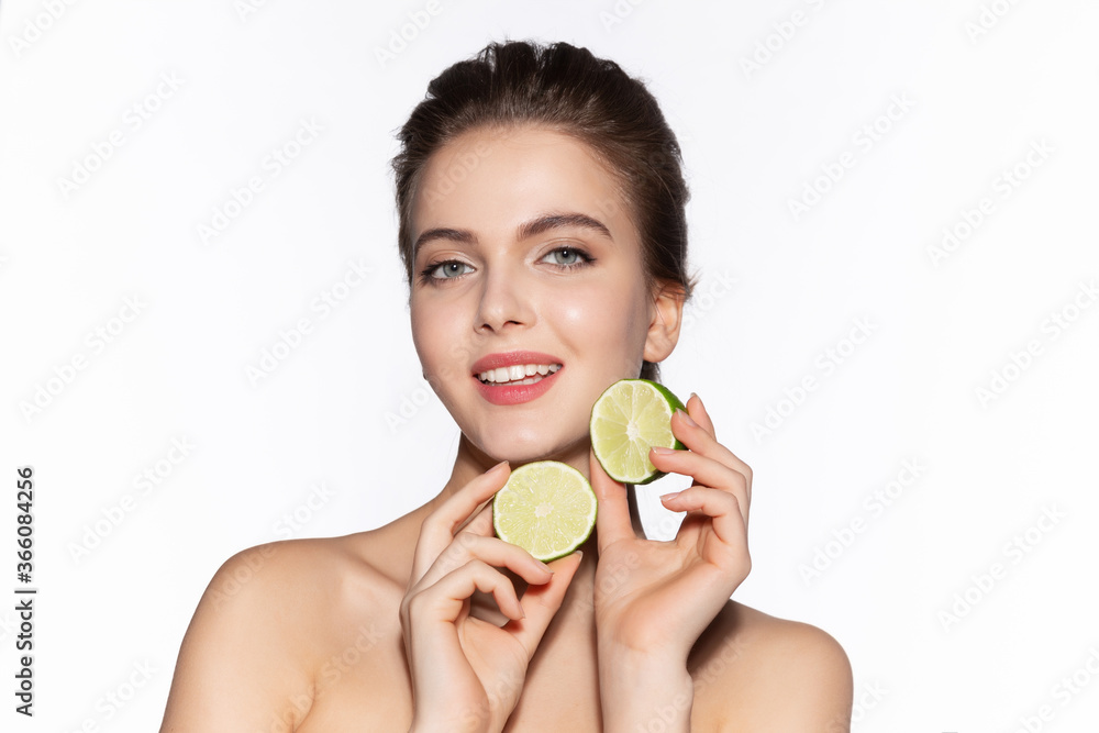 Funny girl shows two halves juicy lime in face. Anti-aging citrus cosmetics. Funny girl shows two halves juicy lime in face. Anti-aging citrus cosmetics.