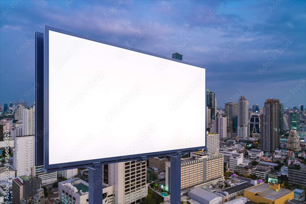 Fototapeta premium Blank white road billboard with Bangkok cityscape background at night time. Street advertising poster, mock up, 3D rendering. Side view. The concept of marketing communication to sell idea.