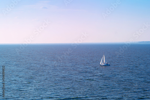 Sailboat in the sea in the evening sunlight over sky background. Luxury summer adventure or active vacation concept. Copy space