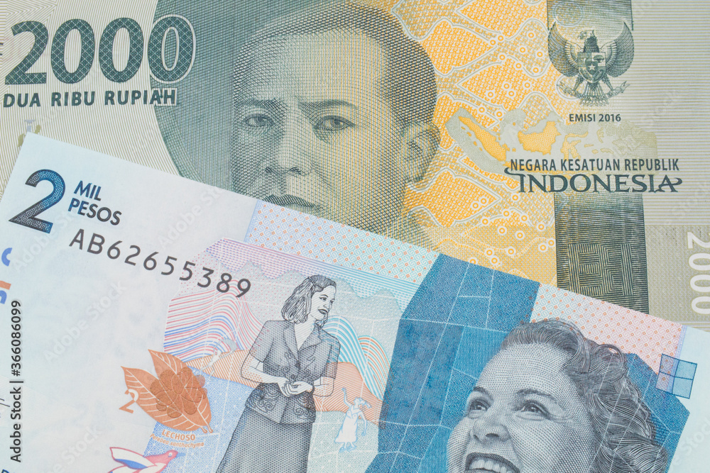 A macro image of a grey two thousand Indonesian rupiah bank note paired up with a blue two thousand bank note from Colombia.  Shot close up in macro.