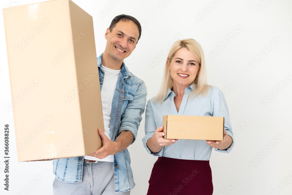 people, delivery, shipping and postal service concept - happy couple opening cardboard box or parcel at home people, delivery, shipping and postal service concept - happy couple opening cardboard box or parcel at home