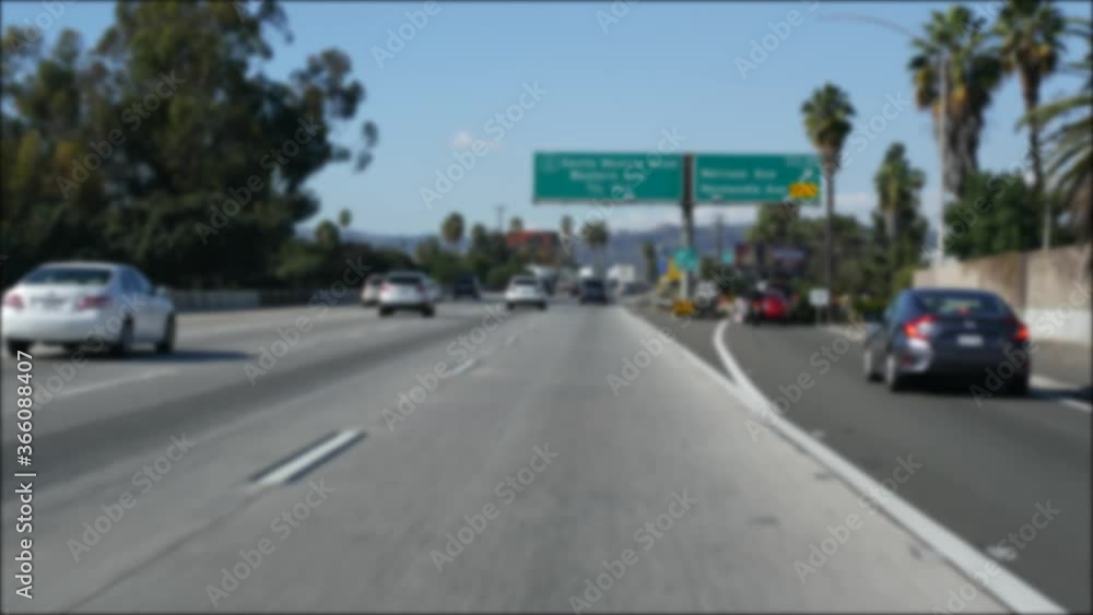 Driving on intercity freeway in Los Angeles, California USA. Defocused view from car thru glass windshield on busy interstate highway. Blurred suburb multiple lane driveway. Camera inside auto in LA. Driving on intercity freeway in Los Angeles, California USA. Defocused view from car thru glass windshield on busy interstate highway. Blurred suburb multiple lane driveway. Camera inside auto in LA.