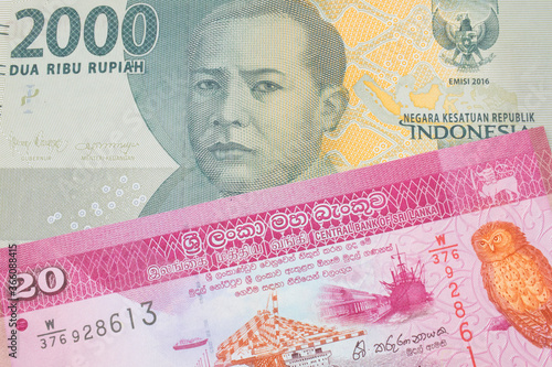 A macro image of a grey two thousand Indonesian rupiah bank note paired up with a pink and white twenty rupee bank note from Sri Lanka.  Shot close up in macro. photo