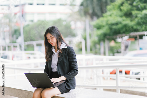 asian business woman using laptop computer while outdoor