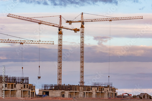 Two tower cranes stand near...