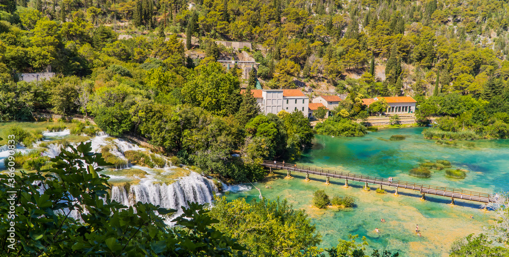Panoramic aerial view of waterfalls, swimmers, and bridge in Krka National Park, Dalmatia, Croatia