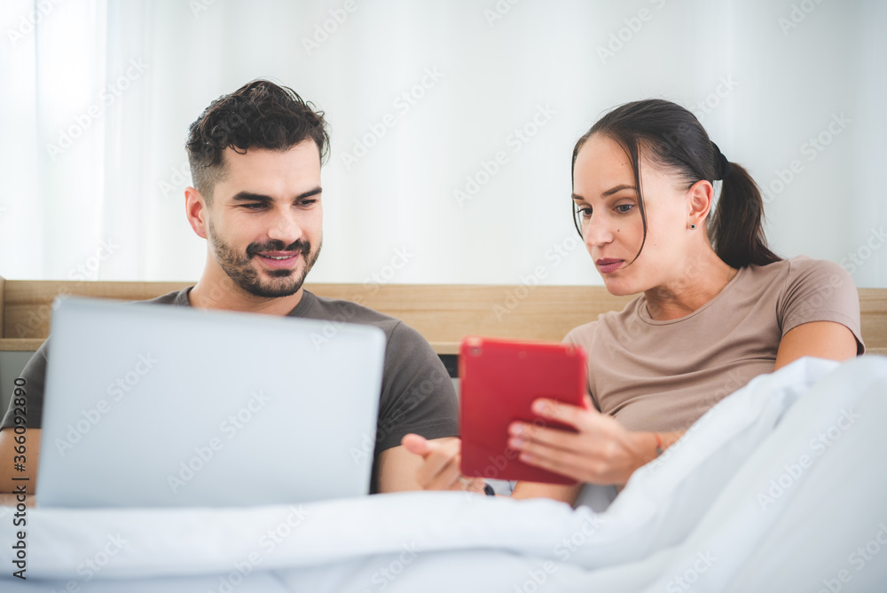 couple working on bed with laptop and tablet, work from home concept couple working on bed with laptop and tablet, work from home concept