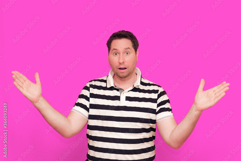 Caucasian man wearing casual striped t-shirt standing over isolated hot pink background shows various gestures. Caucasian man wearing casual striped t-shirt standing over isolated hot pink background shows various gestures.