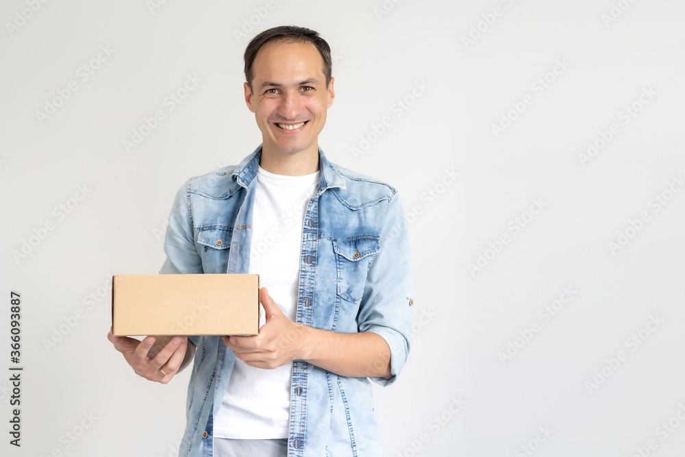 smiling delivery man holding a big parcel isolated on white smiling delivery man holding a big parcel isolated on white