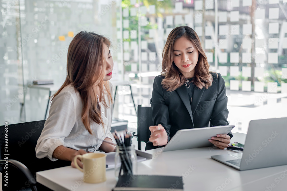 Obraz premium Two young asian businesswoman talking and working together at office.