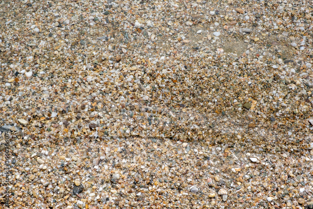 Small pebbles and sand seabed background texture under clear shallow sea water, top view. Small pebbles and sand seabed background texture under clear shallow sea water, top view.