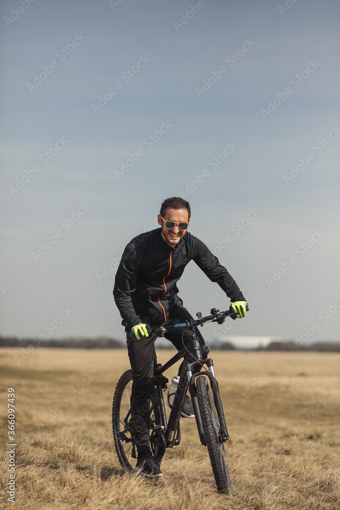 Young man riding a bike on grass field Young man riding a bike on grass field